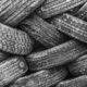 Large pile of used tires tangled together in grayscale image.