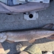 Large speckled fish laid on a boat deck, being measured with a ruler, with hands holding head and tail nearby.